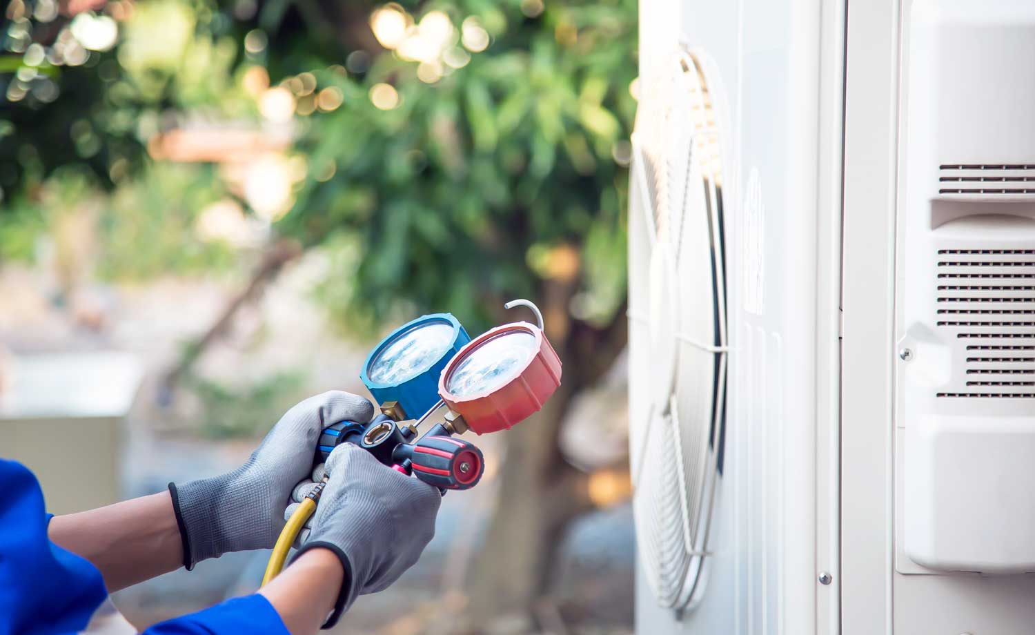 person repairing air conditioning systems outside a home